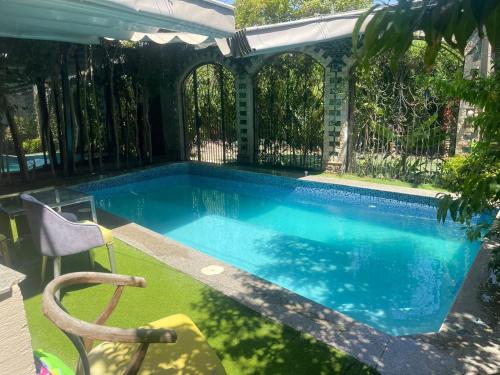 a swimming pool in a yard with a fence at modern villa with coverable pool sheik zayed in Sheikh Zayed