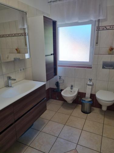 a bathroom with a tub and a toilet and a sink at Ferienwohnung Schamne in Wutöschingen