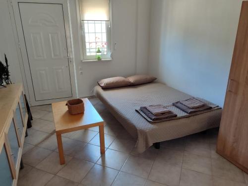 a small bedroom with a bed and a table at Nicholas House in Siviri