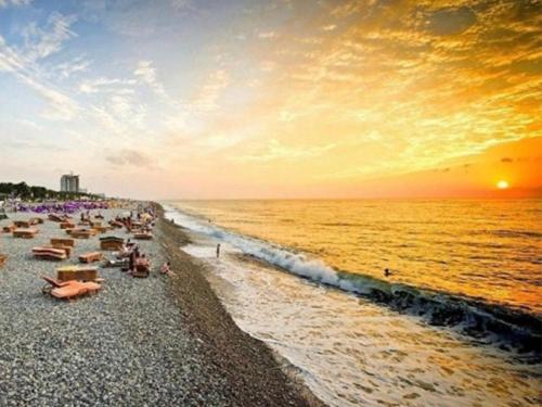 a crowd of people on a beach at sunset at Hotel Park in Batumi