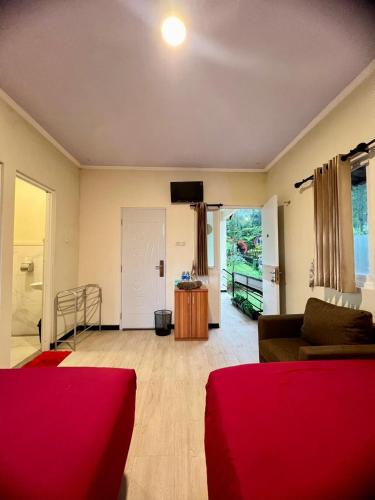 a living room with a red couch and a tv at de Pipo Bromo in Sukapura