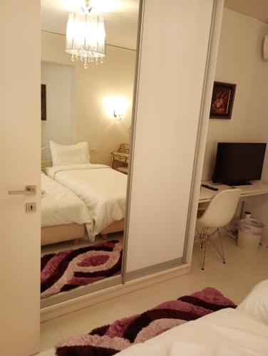 a mirror in a bedroom with a bed and a desk at Villa Kokalis Resort hotel in Gouves
