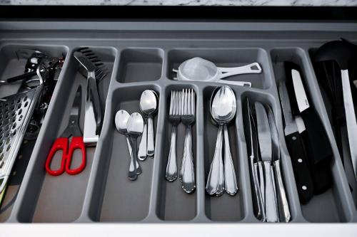 a tray of utensils in a drawer with utensils at Sunny Suite with lake view in Melide