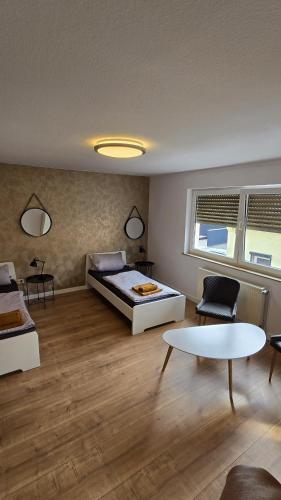 a bedroom with a bed and a table in a room at Ferienwohnung Regina in Undenheim