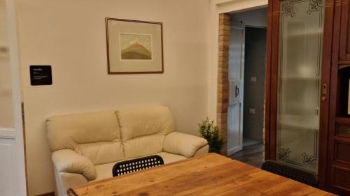 un soggiorno con un divano e un tavolo di legno di zona Ospedali - piano terra tranquillo - clima - Nina a Padova