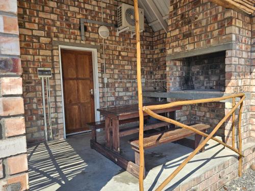 a brick building with a wooden staircase next to a door at Carlo's Mountain Lodge in Usakos