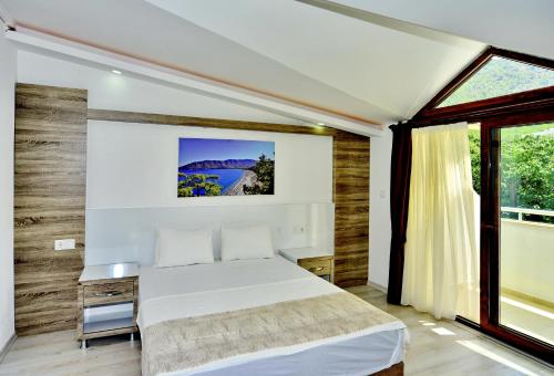 une chambre avec un lit blanc et une fenêtre dans l'établissement Margaritaotel, à Kumluca