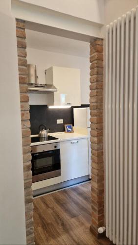 una cucina con banconi bianchi e un muro di mattoni di zona Ospedali - piano terra tranquillo - clima - Nina a Padova