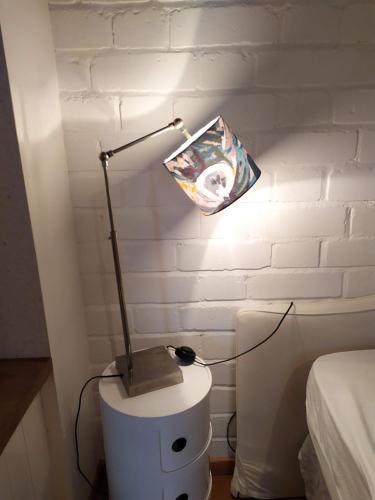 une lampe sur une table blanche dans une chambre dans l'établissement Maison de charme dans un environnement exceptionnel, à Vannes