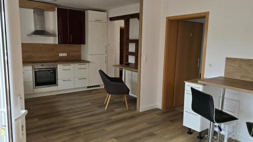 a kitchen with two chairs and a table in it at Ferienwohnung Regina in Undenheim