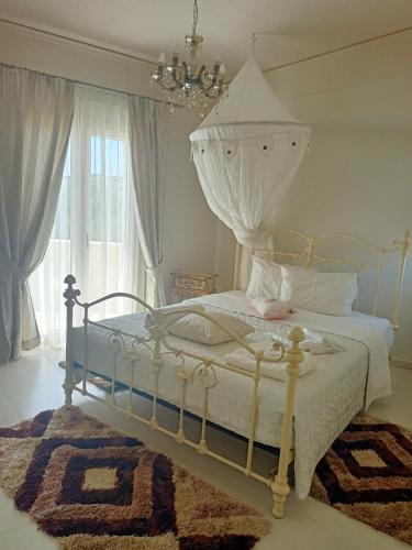 a bedroom with a bed and a chandelier at Villa Kokalis Resort hotel in Gouves
