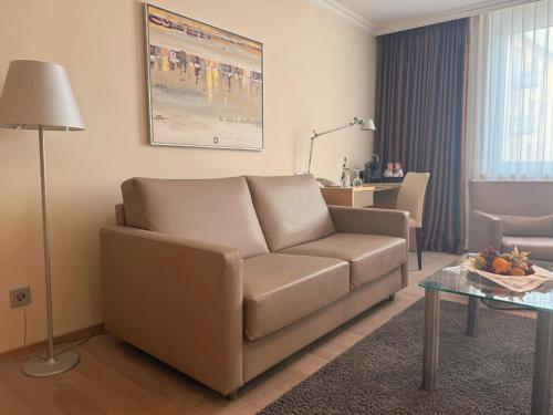 a living room with a couch and a table at Strandhotel Georgshöhe in Norderney