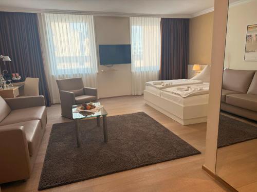 a bedroom with a bed and a table and a couch at Strandhotel Georgshöhe in Norderney