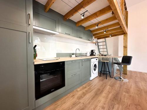 La cuisine est équipée de placards verts, d'un évier et d'un lave-vaisselle. dans l'établissement Loft spacieux et lumineux à 200m du Scorff, à Lorient