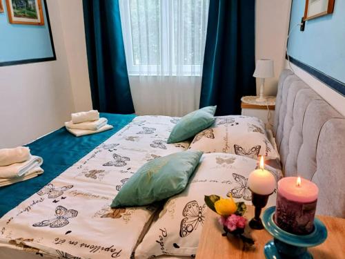 a room with two beds and two candles on a table at Unicum Vendégház in Abádszalók