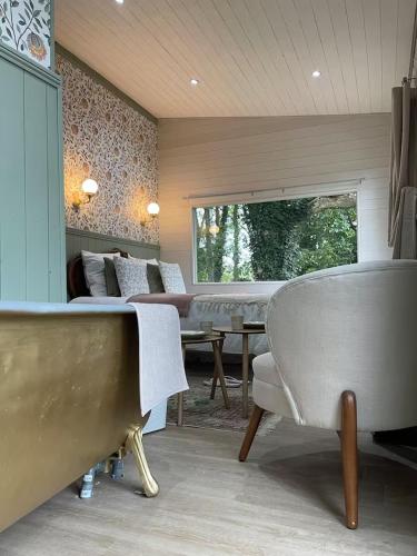 un salon avec un canapé, une table et des chaises dans l'établissement Le cottage du Manoir 1900, à La Ferté-Gaucher