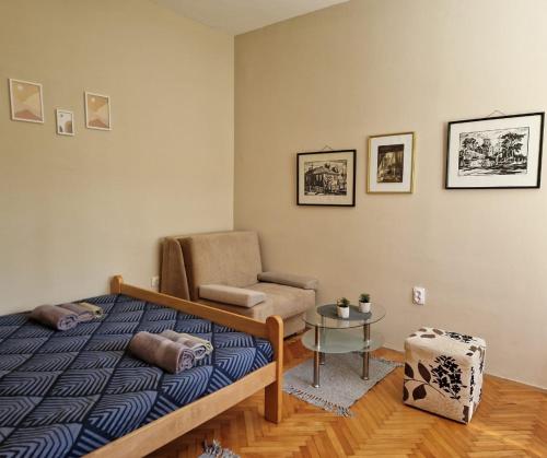 弗尔尼亚奇卡矿泉镇Apartmani Central Vrnjačka Banja Šetalište的一间卧室，里面有一张床、一把椅子和一张桌子