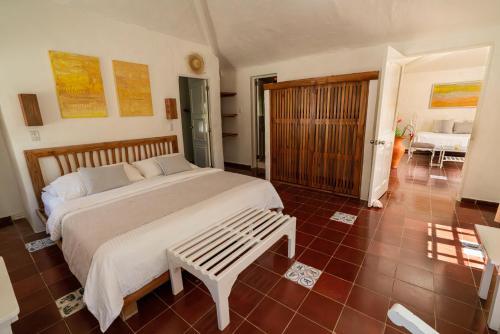 a bedroom with a large bed with a bench in it at Hotel Atlantis in Las Terrenas