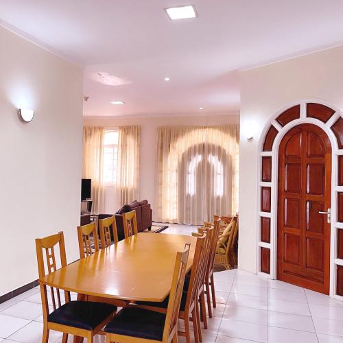 a dining room with a wooden table and chairs at Paramaribo Villa Near Vibrant District incl Kitchen Household Service in Paramaribo
