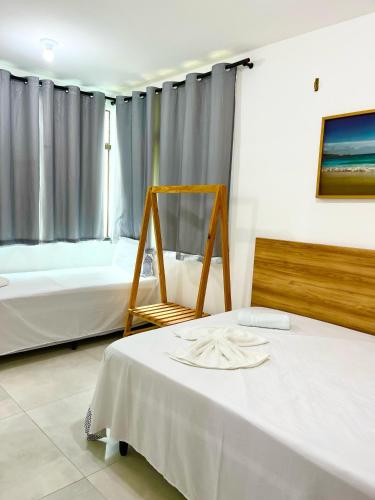 a room with two beds and a table and a chair at Chaleville Barrinha in Barrinha