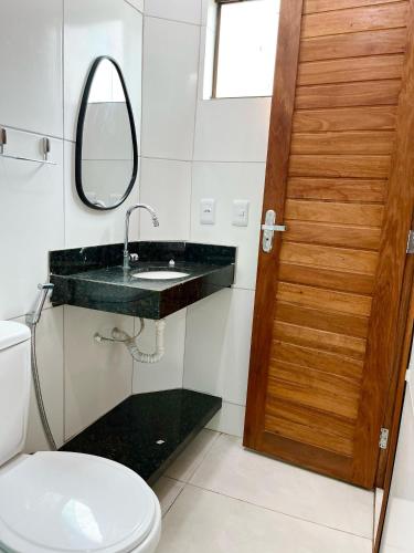 a bathroom with a sink and a mirror and a toilet at Chaleville Barrinha in Barrinha