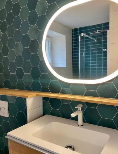 une salle de bain avec un lavabo et un miroir dans l'établissement La cabane des plages, à Plouescat