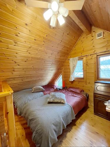 two beds in a log cabin with a ceiling at 919神戸有馬 一棟貸切ログハウスMax6名1日1組限定 in Kobe