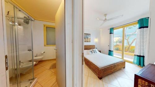 a bedroom with a bed and a bathroom with a shower at Angulo Beach Orchidea in Santa Maria