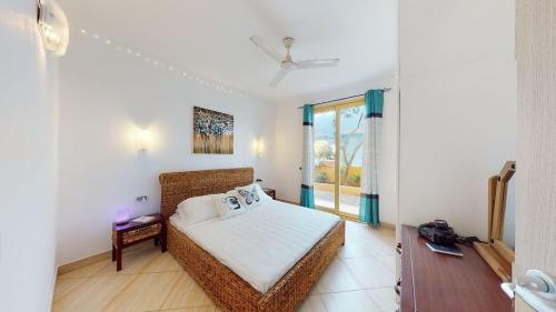 a bedroom with a wicker bed and a window at Angulo Beach Orchidea in Santa Maria