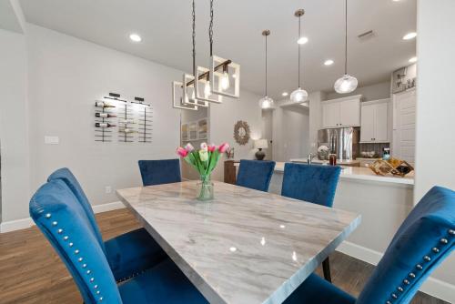 a dining room with a table and blue chairs at Lux Lake, Outdoor Kitchen, Near Fairgrounds in Magnolia