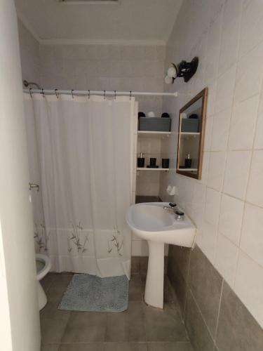 a bathroom with a sink and a shower curtain at Departamento céntrico in Tandil