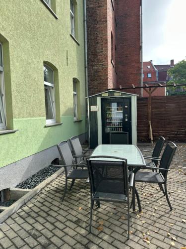 a table and chairs next to a building with a phone booth at Apartment Gray Z2 in Erfurt