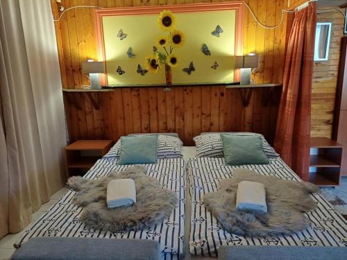 a bedroom with a bed with two pillows and a wall at Unicum Vendégház in Abádszalók