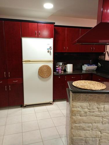 a kitchen with red cabinets and a white refrigerator at Villa Kokalis Resort hotel in Gouves