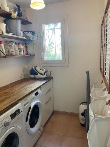 une buanderie avec une machine à laver et une fenêtre dans l'établissement Villa familiale au calme, à Fréjus