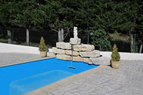 une fontaine avec une statue à côté d'une piscine dans l'établissement Studio climatise avec piscine, à Taluyers