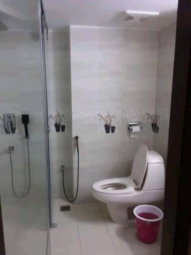 a bathroom with a toilet and a shower with plants at Hotel Ovisar Cox'sBazar in Cox's Bazar