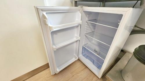 a white refrigerator with its door open in a room at Aparthotel B & L in Bremen