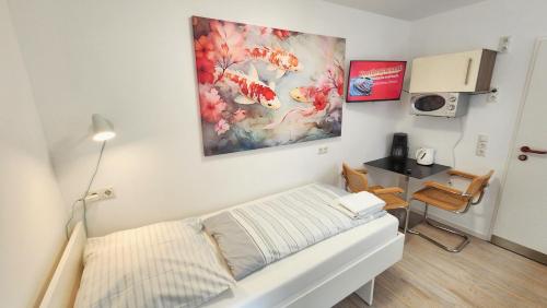 a room with a bed and a desk and a painting at Aparthotel B & L in Bremen