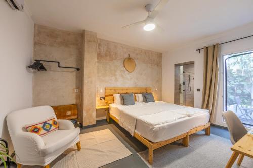 a bedroom with a large bed and a chair at Casa de Océano in Tarifa