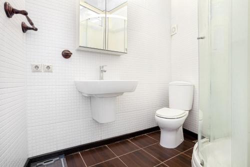 a white bathroom with a sink and a toilet at Roof top, close to Taksim, with private terrace in Istanbul