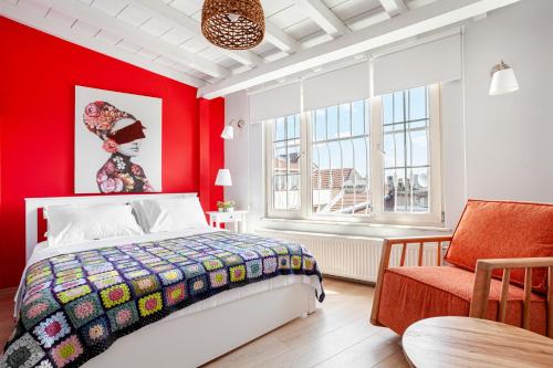 a bedroom with red walls and a bed and a chair at Roof top, close to Taksim, with private terrace in Istanbul