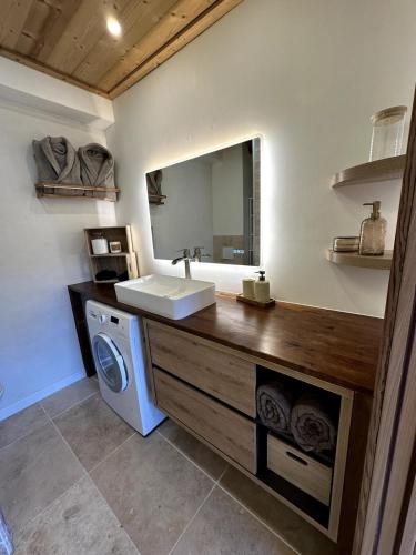 une salle de bain avec un lavabo et une machine à laver dans l'établissement charmant studio à Morzine, à Morzine