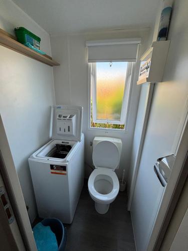 a small bathroom with a toilet and a window at Mobil home camping 4 étoiles in Fréjus