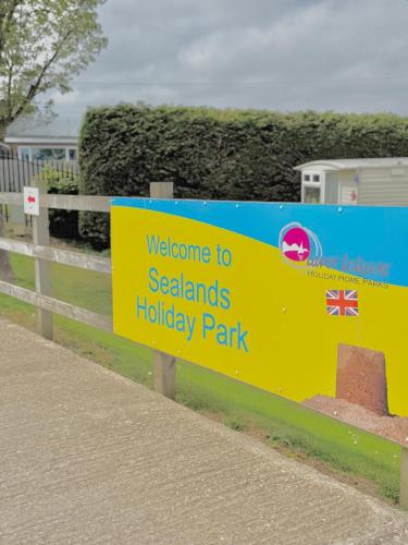a sign for a holiday park on a fence at 2 bedroom cosy caravan, Sealands in Ingoldmells