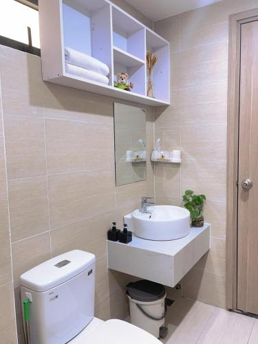 a bathroom with a white sink and a toilet at Joie Apartment Hue in Thôn Văn Dương
