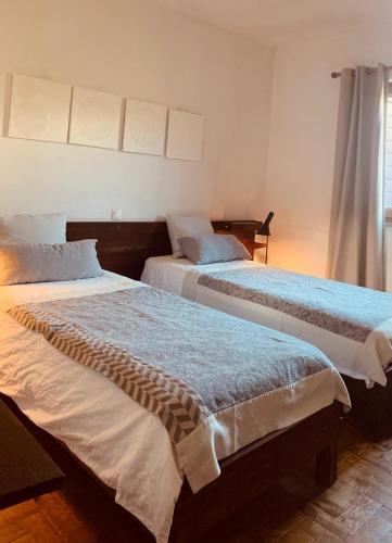 two beds sitting next to each other in a room at 4Sea House in Porto Covo