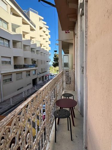 un balcon avec deux chaises et une table sur un immeuble dans l'établissement Studio plages du Mourillon, à Toulon
