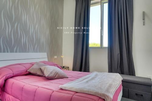 a pink bed in a bedroom with a window at Villa Stella con piscina privata 500 mt dal mare By Sicily Home Solutions in Trappeto