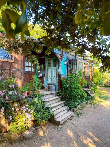 une maison avec une porte bleue et des fleurs dans l'établissement Dortoir dans la nature, à Chambonas
